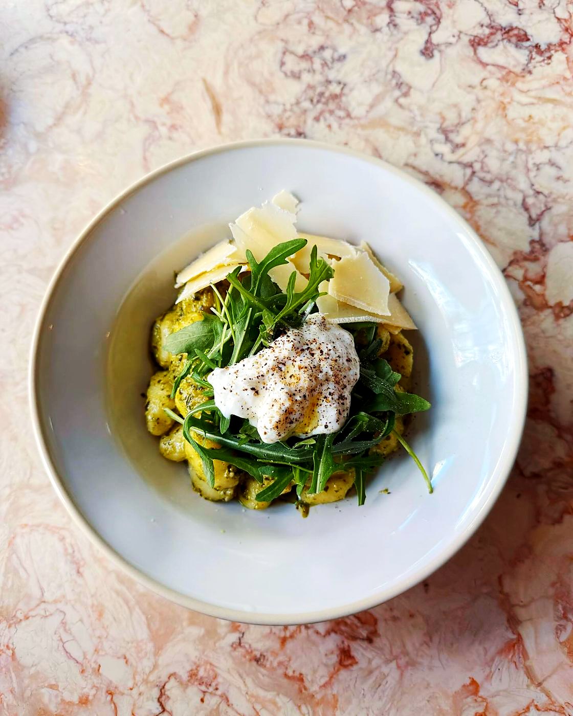 Gnocchi ao pesto com burrata, rúcula e lascas de parmesão